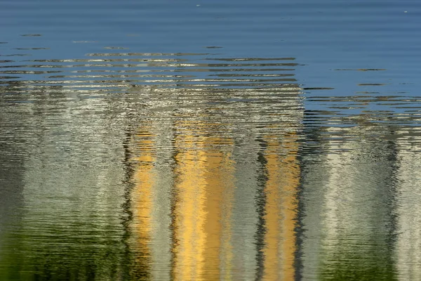 Reflection of houses in the pond of the Park of the Internationalists.