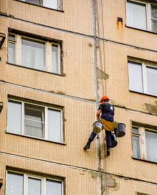 Plakalar arasında dikişler mühürleme. Evin steeplejack onarım bloğu çalışması