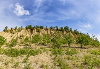 Kireçtaşı çıkarma için ocaklar. Ezilmiş kireçtaşı küçük yığınları oluşan ve yağmurlar tarafından yıkanmış bir höyük.  