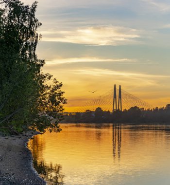 Büyük Obukhov köprüsünden uzakta, St. Petersburg'da Neva nehri üzerinde parlak gün batımı.