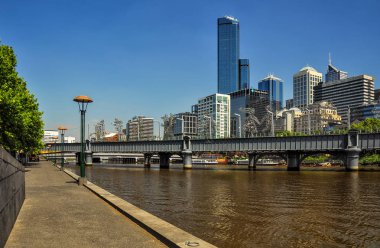 Melbourne, Avustralya, Victoria 18 Aralık 2013. Yarra nehrinin karşısındaki Sundridge 'e yaya köprüsü yakınlığı. Metal heykeller yıllar boyunca Melbourne göç hikayesini anlatmak. 