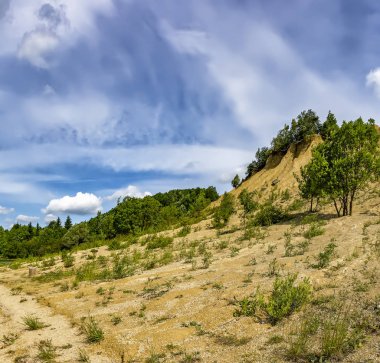 Kireçtaşı çıkarma için ocaklar. Ezilmiş kireçtaşı küçük yığınları oluşan ve yağmurlar tarafından yıkanmış bir höyük.  