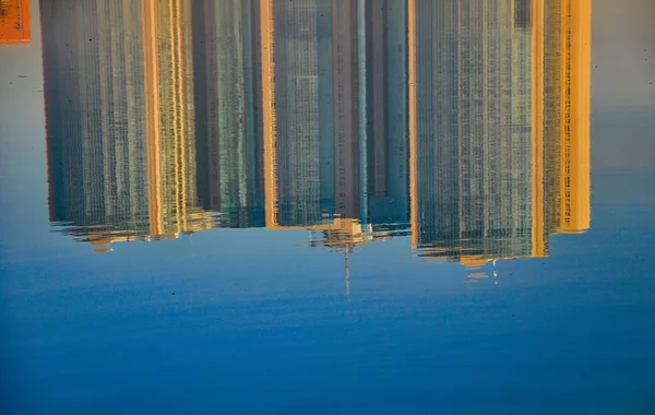 Reflection of houses in the water of the river. Abstract pattern created by the ripples.