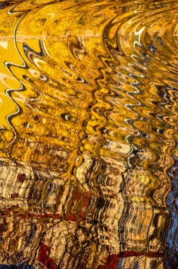 Nehir suyundaki evlerin yansıması. Dalgalanmalar tarafından oluşturulan soyut desen.