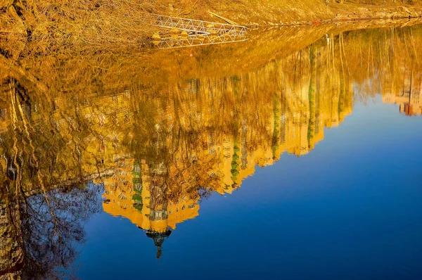 Reflection of houses in the water of the river. Abstract pattern created by the ripples.