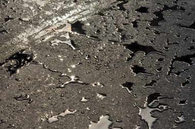 Asfalt yolda yağmur suyu