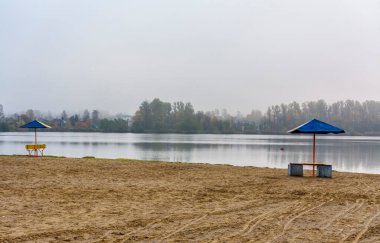 Şehir gölünün kıyısındaki sahilde sisli bir sabah..