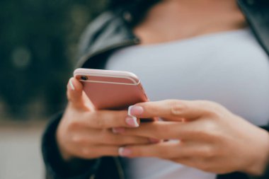 Genç güzel kız kullanan bir akıllı telefon üzerinde sörf internet, cep, cep, video, sosyal street, hücresel, kısa mesaj, dokunmatik ekran, yapmak fotoğraf, selfie