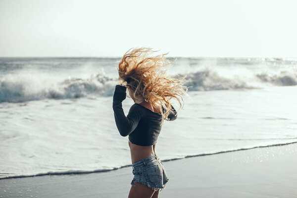 young beautiful girl posing on the beach, ocean, waves, bright sun and tanned skin