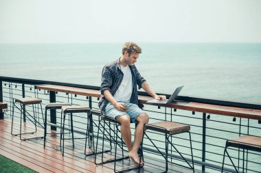 Yakışıklı delikanlı kafede, telefonunuzun ve çikolata yemek, kokteyl, güler yüzlü, suyu, gülen yüz, açık yakın portre kadar için dokunmatik ekran,