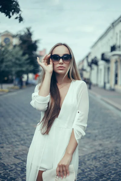 Emotional portrait of Fashion stylish portrait of pretty young hipster blonde woman,going crazy,elegant black hat,soft colors,cool crazy  girl.Red urban wall background.surprised girl close up, sunset