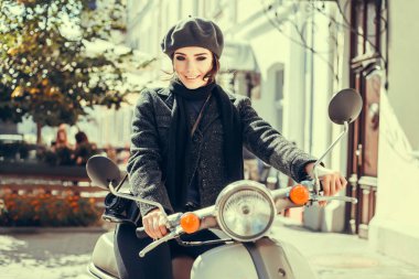 Siyah elbiseli genç kız dışarıda duruyor ve şehirde gün batımını seyrediyor, güneş bir kızın üzerinde ışıl ışıl, şık kıyafetler, hipster tarzı, çanta, güneş, sokak fotoğrafı, özgürlük, New York