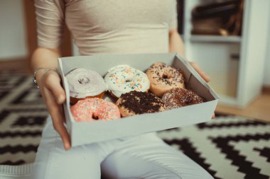 Güzellik model kız tatlılar ve renkli çörekler alarak. Pembe arka plan üzerinde tatlılar ile Komik neşeli Vogue tarzı kadın. Diyet, diyet konsepti. Abur cubur, Zayıflama, kilo kaybı