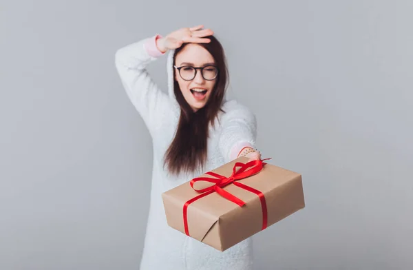 Beautiful girl in white rabbit costume hare posing in studio,and holding a beautiful gift box, laughing and smiling cheerfully, holiday atmosphere,new year and Christmas,outdoor portrait,glasses 2020