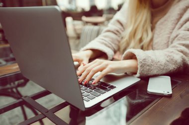 Genç güzel kız bir dizüstü bilgisayar kafe, internet sörf kullanır