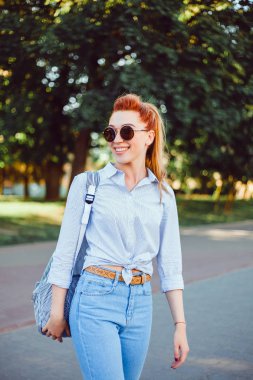 bir sırt çantası ile bir elbise içinde sokakta poz genç güzel kız