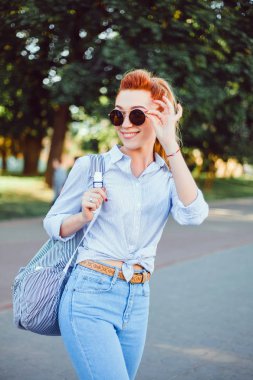 bir sırt çantası ile bir elbise içinde sokakta poz genç güzel kız