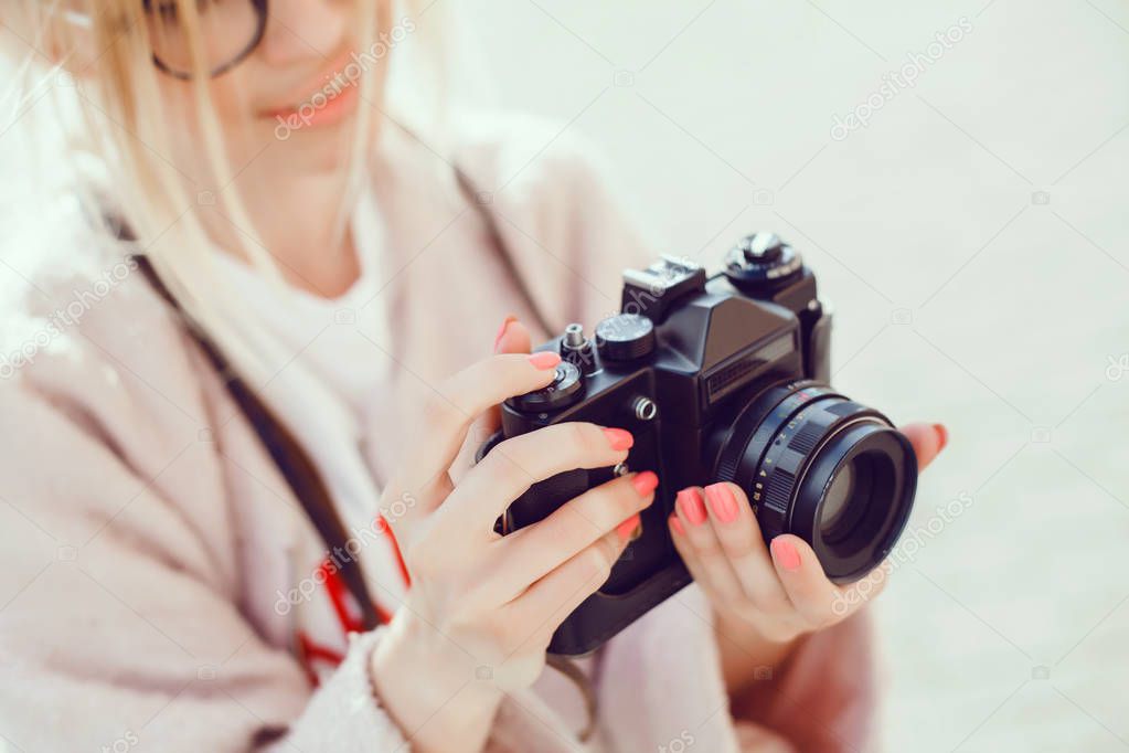 young beauty woman takes pictures on vintage camera, female photographer, chipster, street reporter