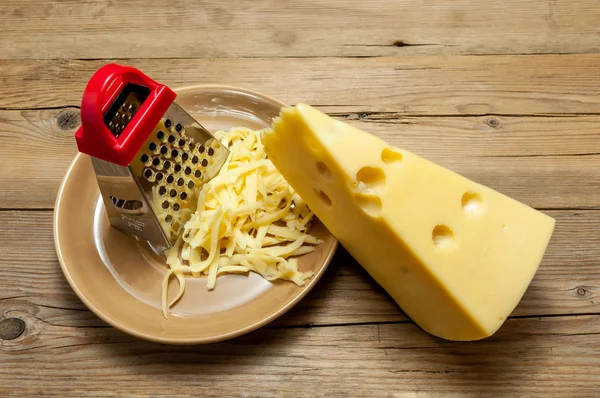 Kırmızı rende, palte bir ışık, eski ahşap tahta üzerinde peynir