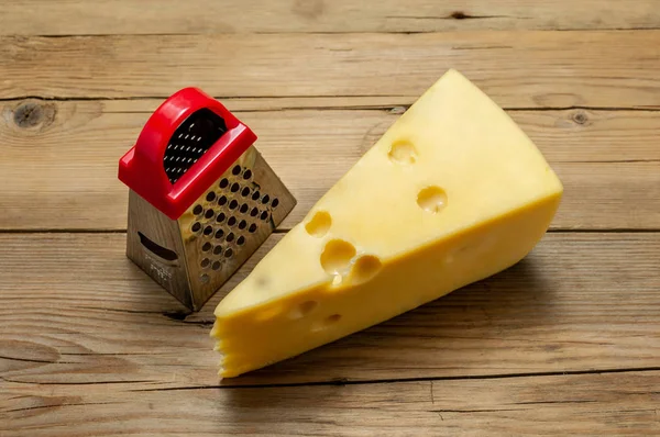 Kırmızı rende, bir ışık, eski ahşap tahta üzerinde parça peynir
