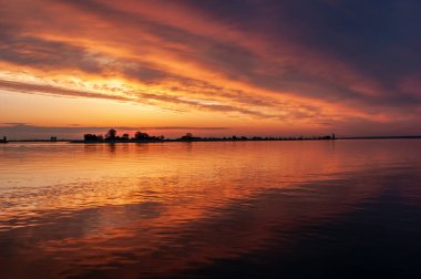 nehir veya rezervuar üzerinde koyu turuncu günbatımı bahar akşamı