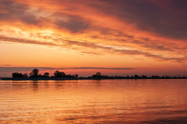 nehir veya rezervuar üzerinde koyu turuncu günbatımı bahar akşamı