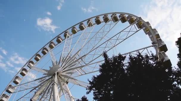 Rueda de la fortuna en el fondo del cielo azul en la ciudad — Vídeos de Stock