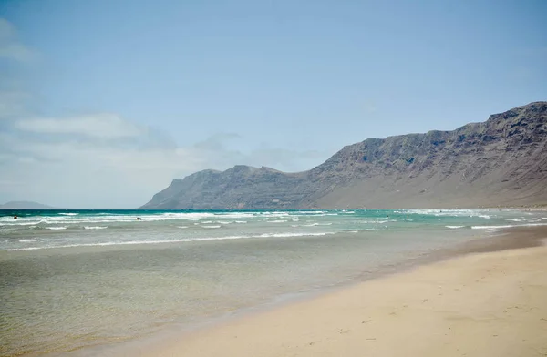 Hermosa vista al océano Atlántico con playa de Surf, rocas y olas al amanecer. Lanzarote, España — Foto de Stock