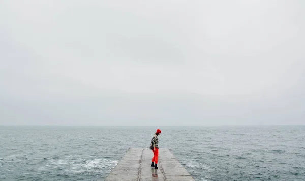 Kış döneminde boş sahilde yürüyen kadın. Sanat fotoğrafı ile film ve tahıl süzgeç eklendi