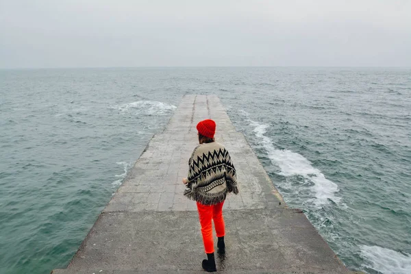 Frau, die im Winter am leeren Strand spazieren geht. Kunstfoto mit zusätzlicher Folie und Kornfilter — Stockfoto