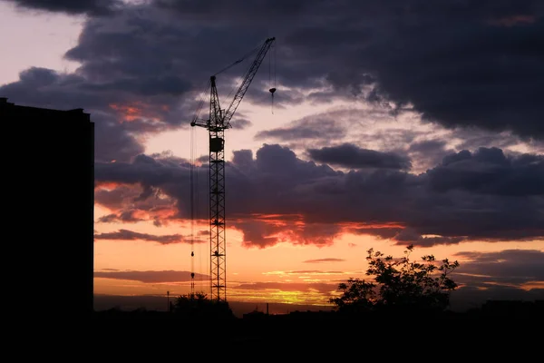 Pôr do sol dramático na paisagem urbana com guindaste — Fotografia de Stock