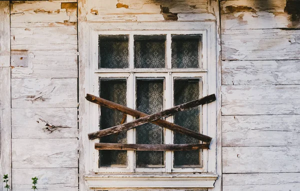 Terk edilmiş eski bir binanın penceresine tahta çakılmış.. — Stok fotoğraf