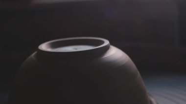 Kadın çömlekçi çömlek çarkında demlik yapıyor. Potter iş yerinde, kapat. El yapımı, el yapımı. Beyaz kil