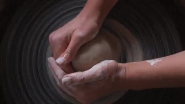 Joven artista Manos Potter haciendo olla de cerámica hecha a mano en la rueda de cerámica retorcida. Vista superior. Concepto artesanal. Arcilla blanca — Vídeos de Stock