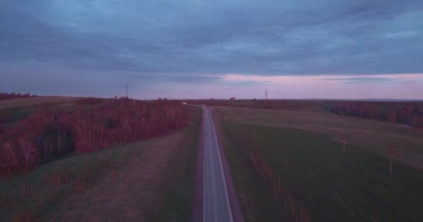 Повітряний вид на пейзаж з поїздкою на шосе вантажівок і кілька автомобілів на заході сонця і хмар. 4-кілометровий — стокове відео