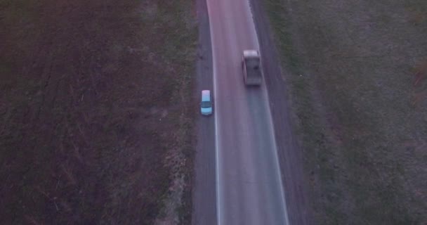 Повітряний вид на пейзаж з поїздкою на шосе вантажівок і кілька автомобілів на заході сонця. 4-кілометровий — стокове відео