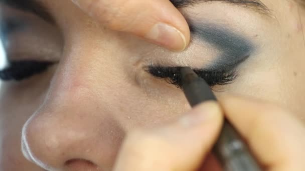 Профессиональный визажист делает макияж глаз на клиентском лице. индустрия моды — стоковое видео