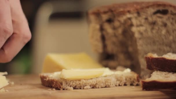 Κοπή τυρί σε ένα ξύλινο ταμπλό. Γκρο πλαν άνθρωπος χέρι με μαχαίρι — Αρχείο Βίντεο