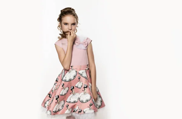 Linda niña en vestido rosa sobre fondo blanco. Moda infantil, concepto de estilo. espacio libre para texto — Foto de Stock