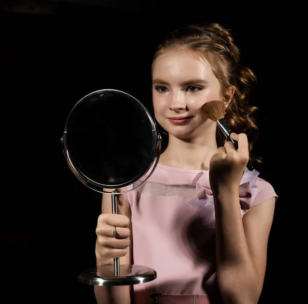 Κοριτσάκι με στρογγυλό καθρέφτη κάνω μακιγιάζ σε σκούρο φόντο — Φωτογραφία Αρχείου