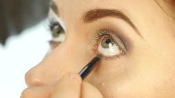 Artista de maquiagem profissional aplicando maquiagem para olhos, sombras e delineador. câmara lenta — Vídeo de Stock