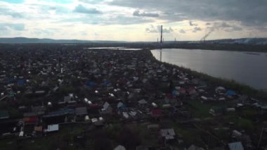 Havadan görünümü. gün batımı göl kıyısında bir küçük şehir ile yukarıda. Endüstriyel Tesis bir ufuk üzerinde. 4k