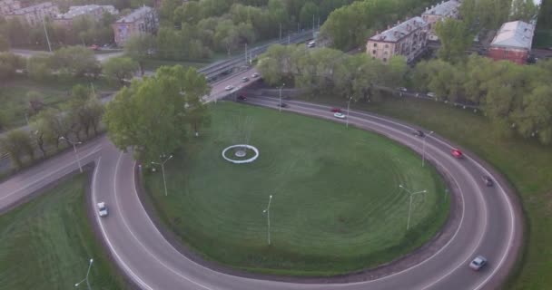 Vue de dessus rond carrefour routier dans la ville smoll au coucher du soleil. voitures de circulation urbaines actives. Vol aérien. 4K — Video