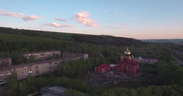 Vista superior da grande construção do templo cristão perto da rodovia em pequena cidade. 4K — Vídeo de Stock