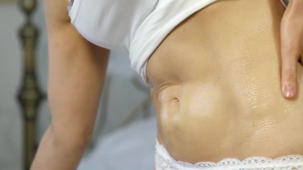 Vrouw room toe te passen op haar buik. lichaam verzorging en huid concept. Slow motion — Stockvideo