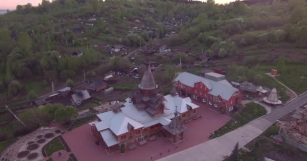 Vista aérea da igreja de madeira na cidade pequena no por do sol. Templo Cristão em estilo antigo. 4K — Vídeo de Stock