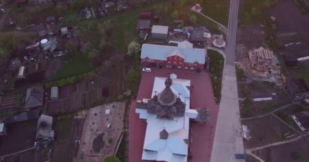 Vista aérea da igreja de madeira na cidade pequena no por do sol. Templo Cristão em estilo antigo. 4K — Vídeo de Stock