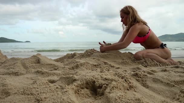 Vacker smal kvinna leker med sand på exotisk strand — Stockvideo