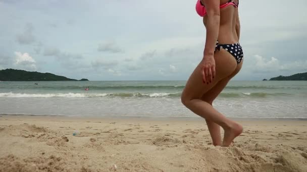 Schöne schlanke Frau ruht sich an einem sonnigen Sandstrand aus — Stockvideo