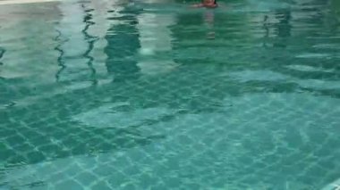 Otel yüzme havuzu ve caming dışarı içine ince güzel kadın gelir. yaz tatil kavramı